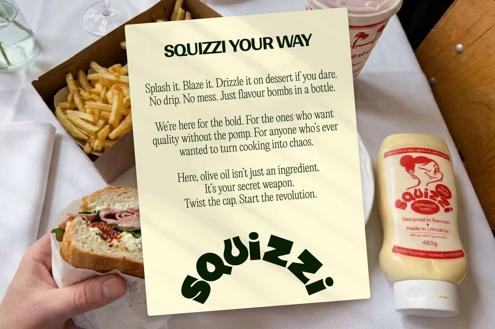 Squizzi Your Way manifesto card on a table with a sandwich and fries